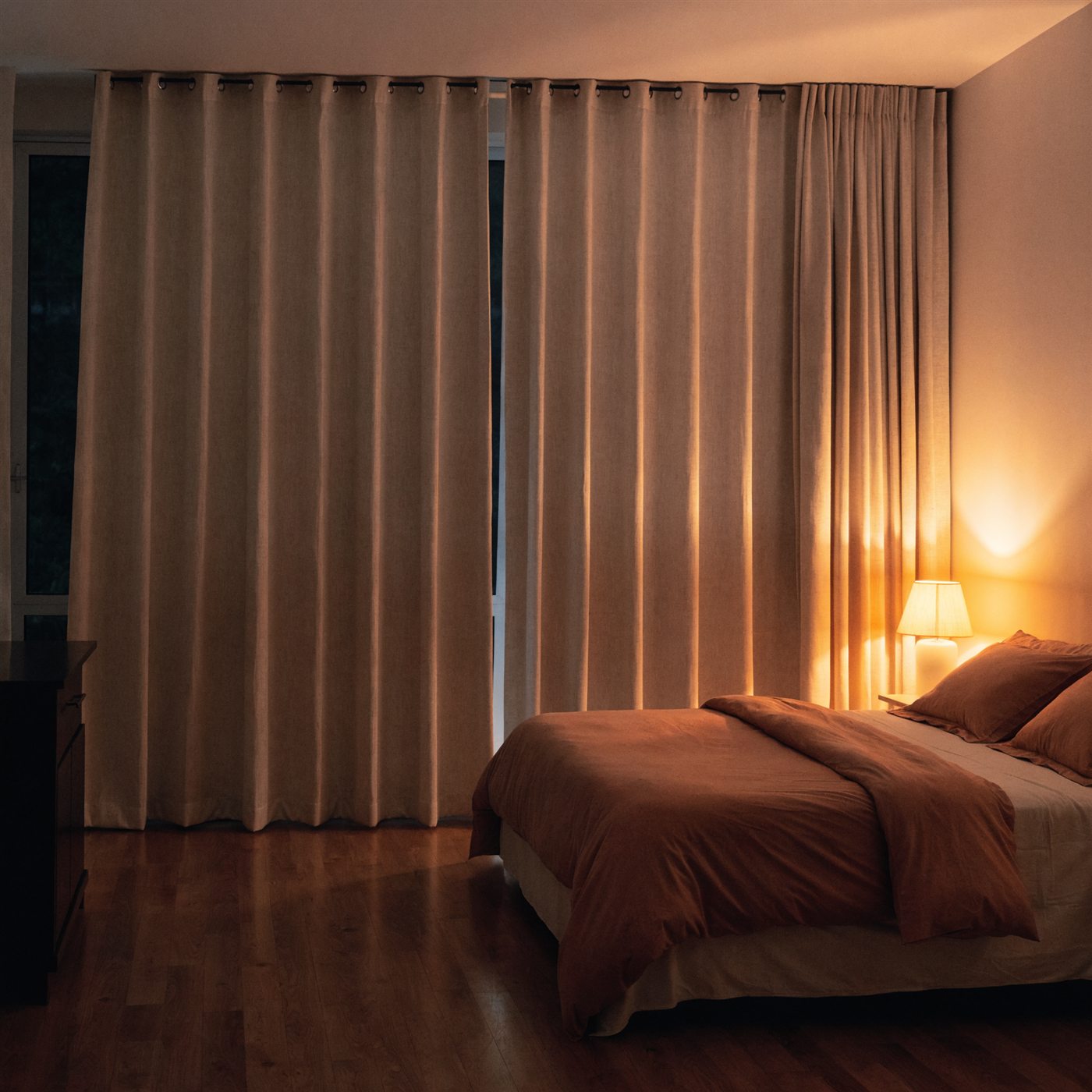 Dormitorio con cortinas blackout en tonos cálidos